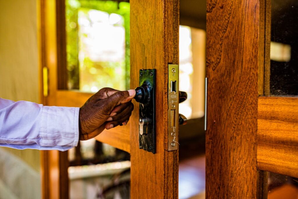 main qui ferme une porte-fenêtre à clé